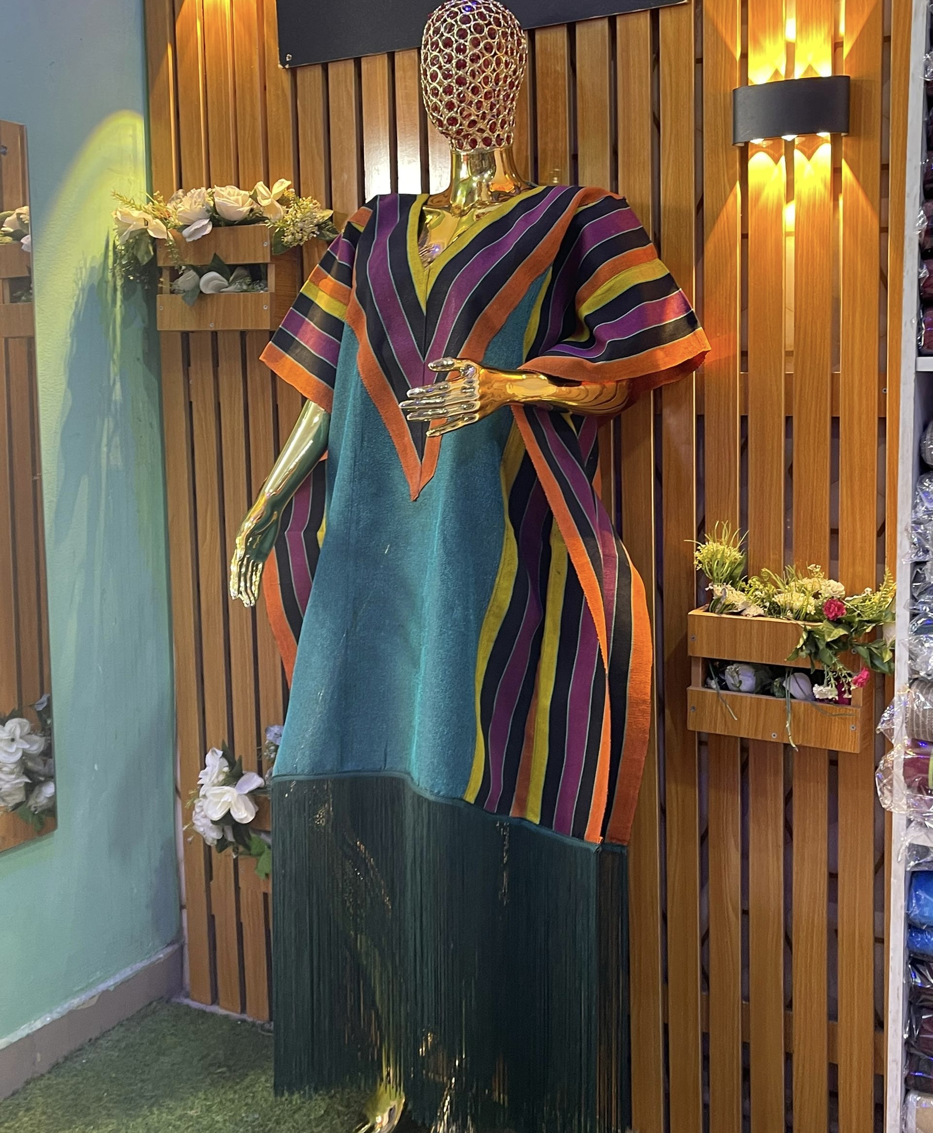 Teal kaftan with vivid orange and purple V-stripes and green fringe